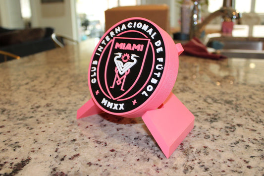 Inter Miami 3D printed emblem on a countertop, vibrant colors, stylish decor for soccer fans.