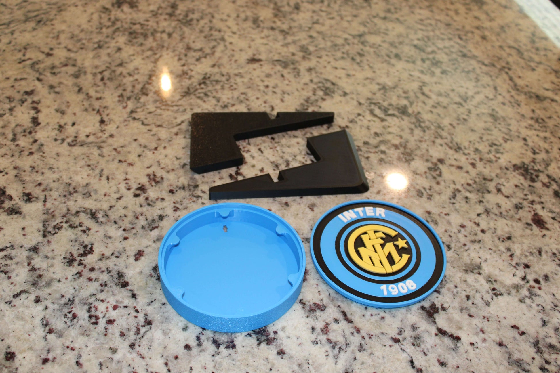 Inter Milan Retro 3D Printed Emblem pieces on granite surface, showcasing vibrant colors and unique design for fans.