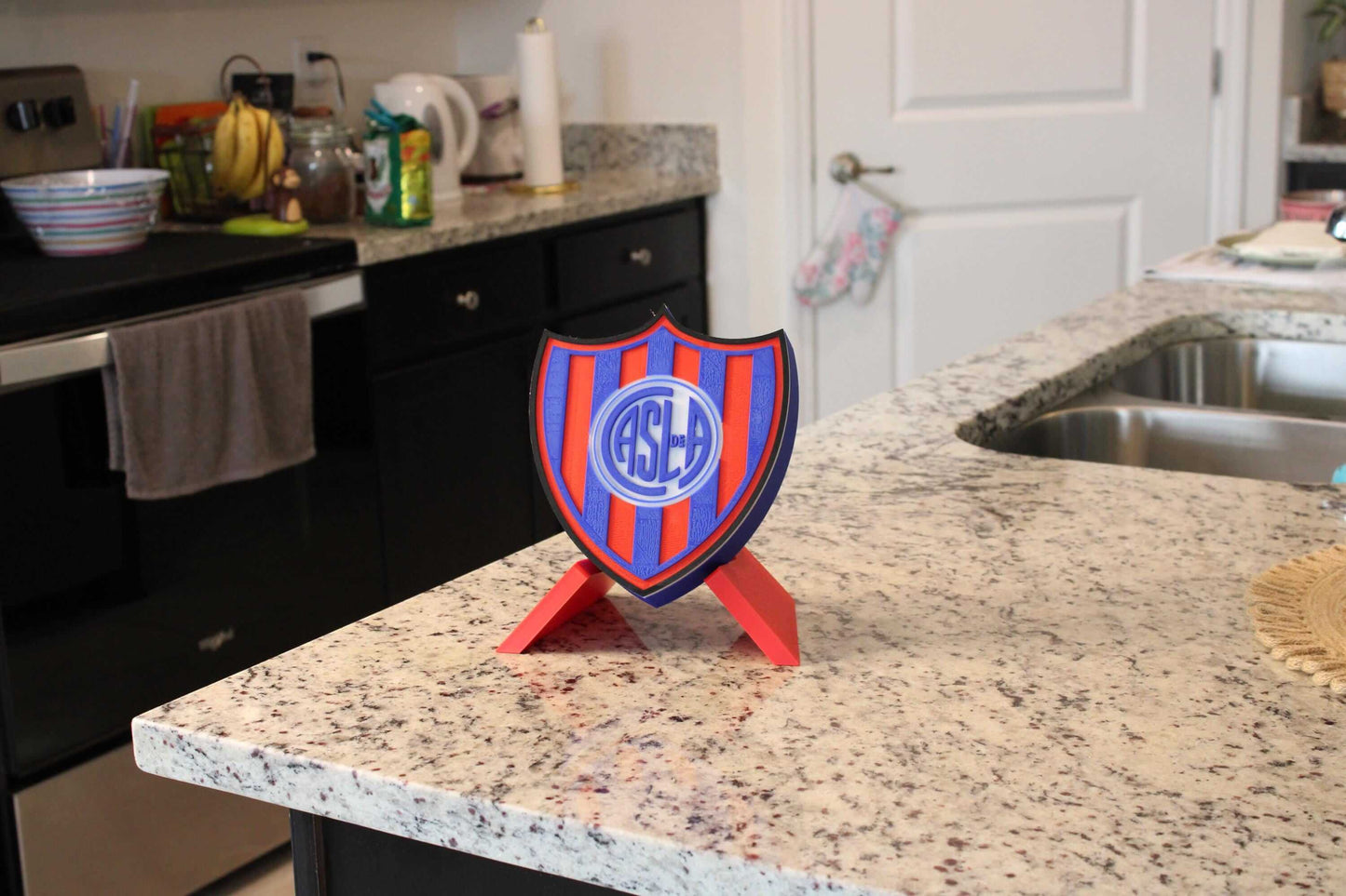 Vibrant 3D printed San Lorenzo emblem on kitchen countertop, showcasing bold colors and unique design for fans.