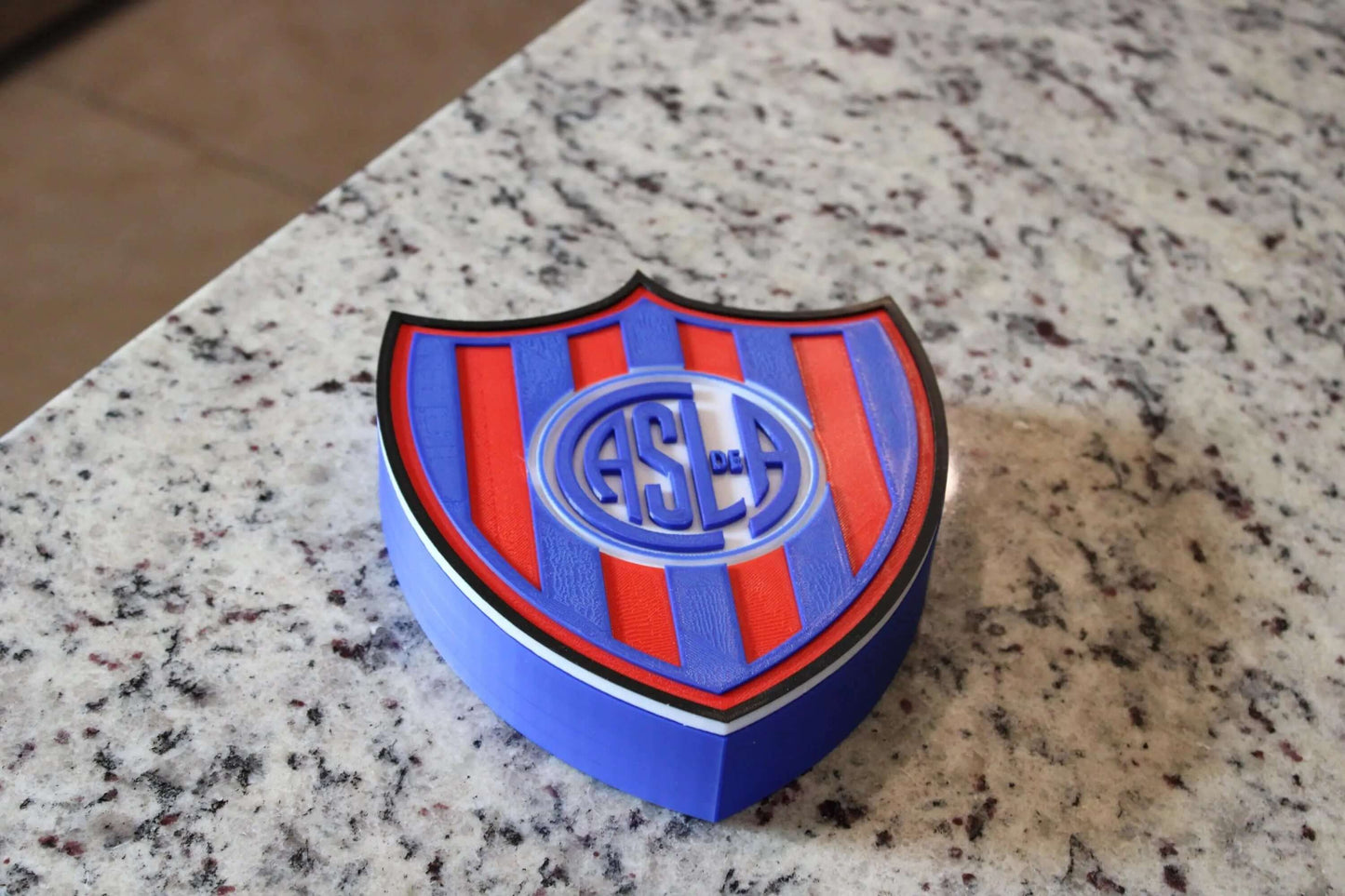 San Lorenzo 3D printed emblem on a countertop, showcasing vibrant colors and unique design for fan collectors.